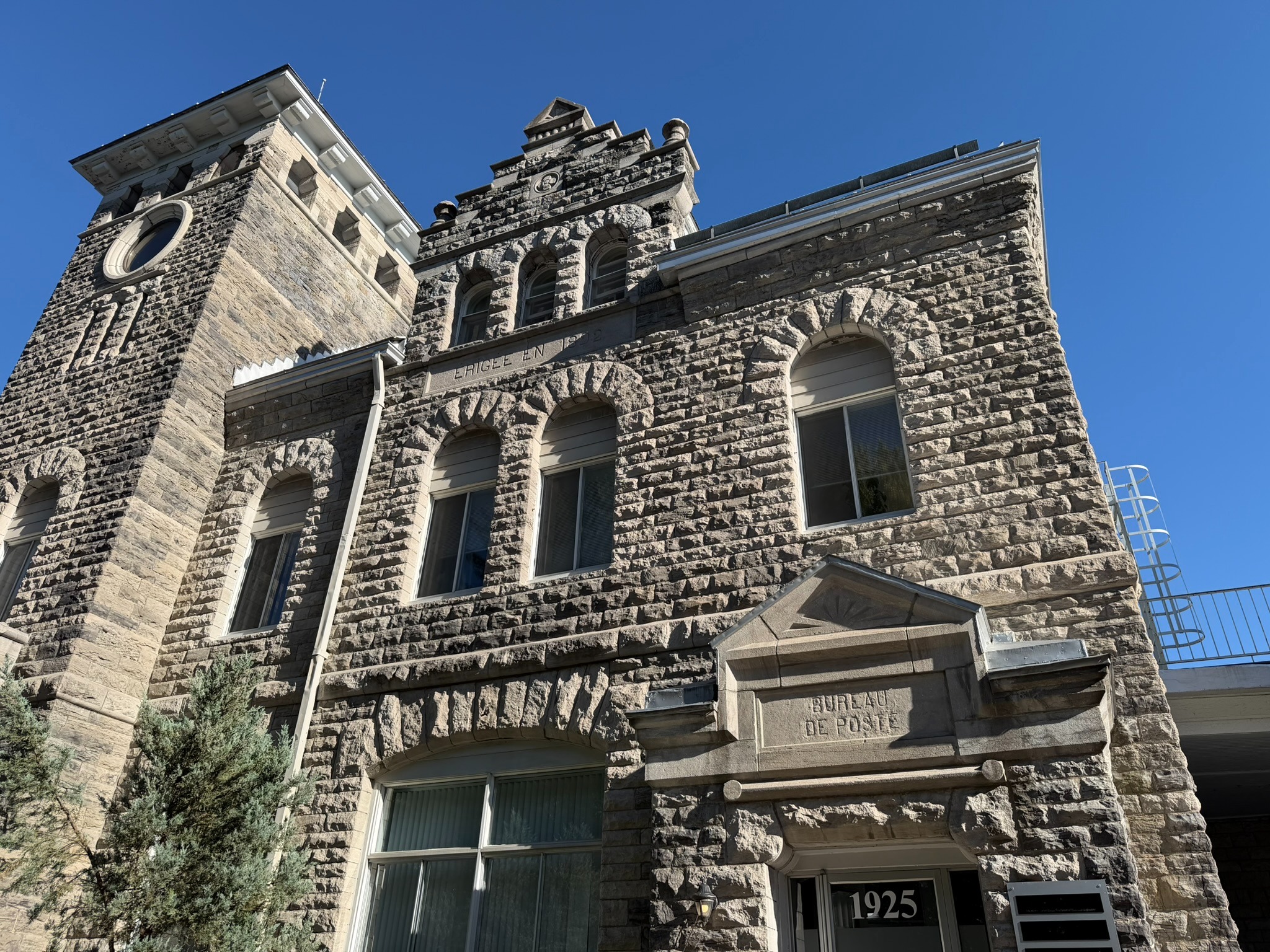 Façade en pierre du bâtiment de la clinique, avec son entrée portant le numéro 1925.